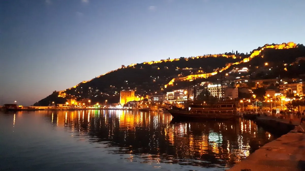 Gece ışıklandırılmış Alanya Kalesi, liman ve denize vuran ışıklar
